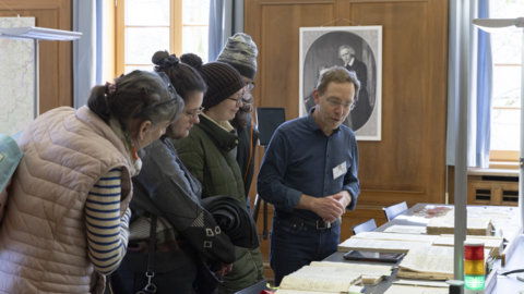 Interessant und informativ: Archivalienschau am "Tag der Archive" in Marburg Foto: Ein Mann erklärt vier Frauen Archivalien, die auf einem Tisch liegen